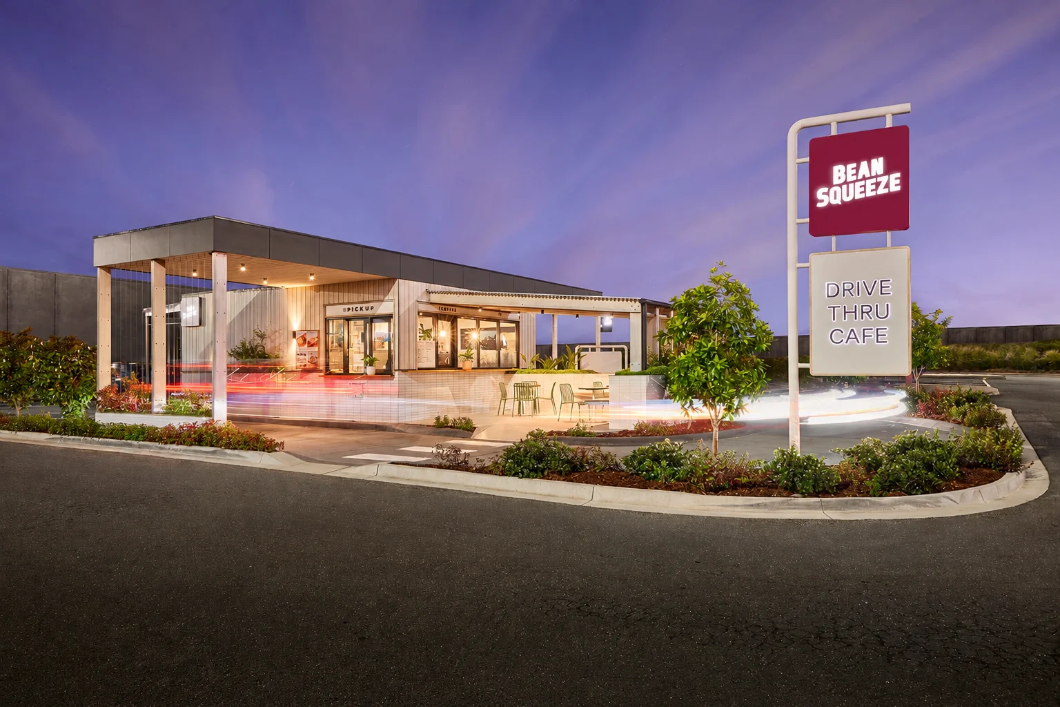 Bean Squeeze drive-thru store at twilight with its red logo and Drive Thru Cafe sign