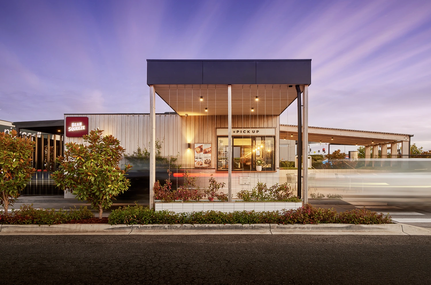 Bean Squeeze drive-thru store building with its red illuminated sign